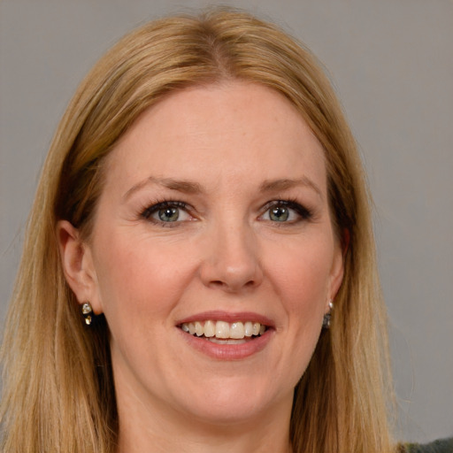 Joyful white adult female with long  brown hair and blue eyes