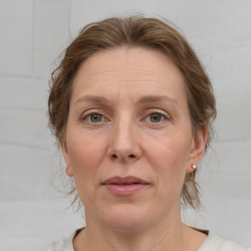 Joyful white adult female with medium  brown hair and grey eyes