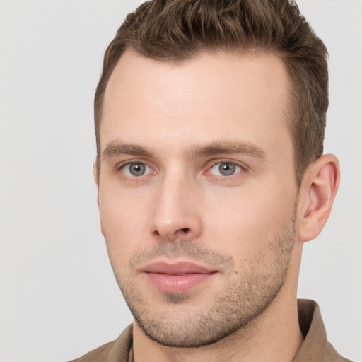 Joyful white young-adult male with short  brown hair and grey eyes