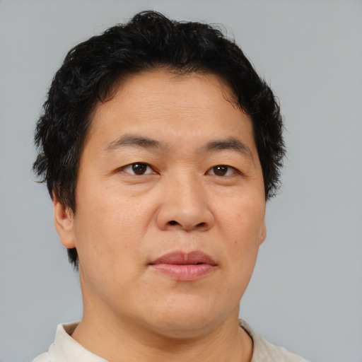 Joyful asian adult male with short  brown hair and brown eyes