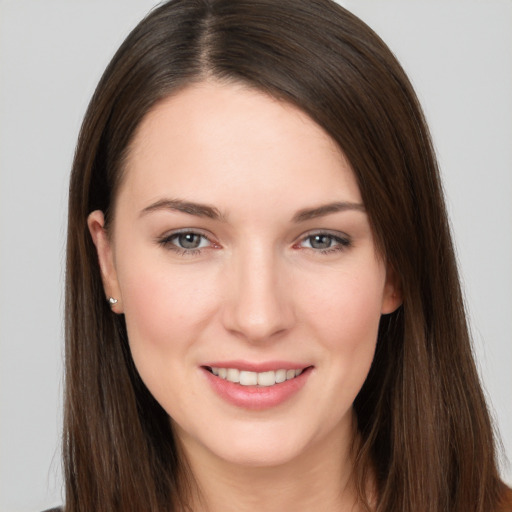 Joyful white young-adult female with long  brown hair and brown eyes