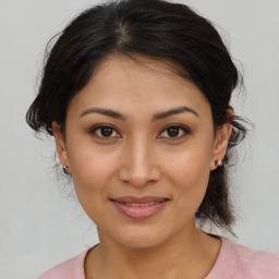 Joyful latino young-adult female with medium  brown hair and brown eyes