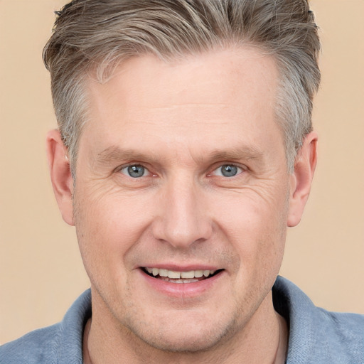 Joyful white adult male with short  brown hair and grey eyes