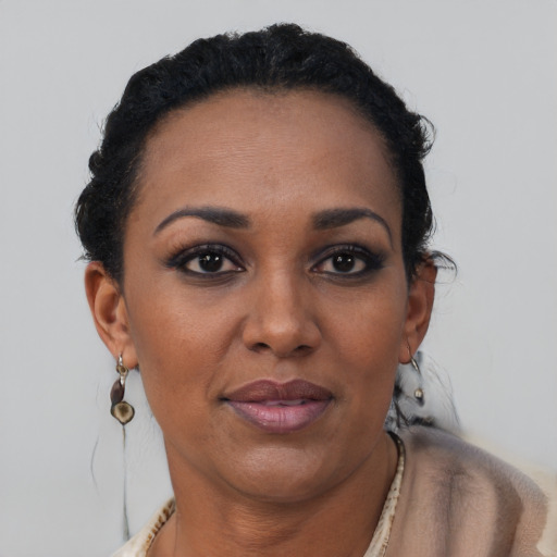 Joyful black adult female with short  brown hair and brown eyes