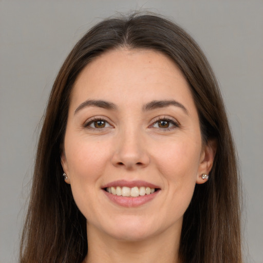 Joyful white young-adult female with long  brown hair and brown eyes