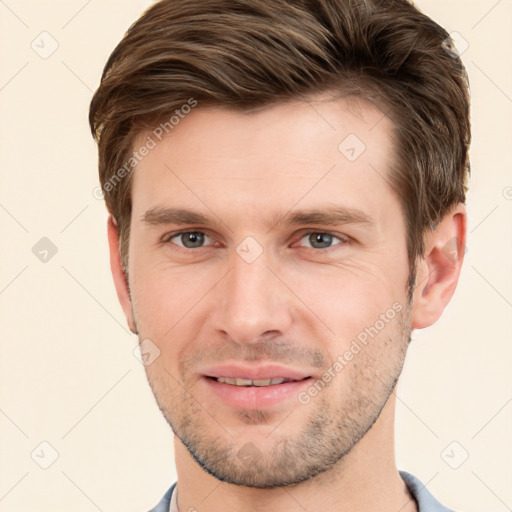 Joyful white young-adult male with short  brown hair and grey eyes