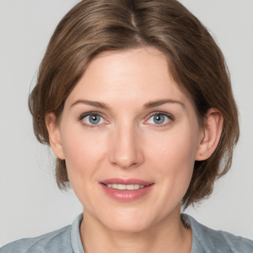 Joyful white young-adult female with medium  brown hair and grey eyes