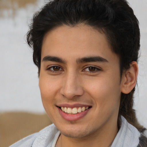 Joyful latino young-adult male with short  brown hair and brown eyes