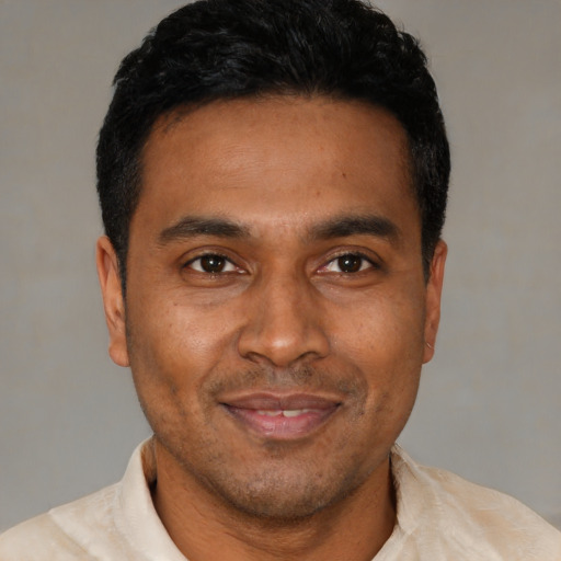 Joyful black young-adult male with short  black hair and brown eyes