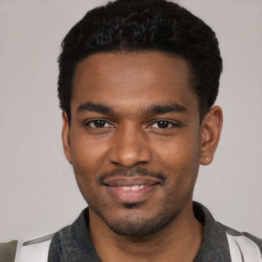 Joyful black young-adult male with short  black hair and brown eyes