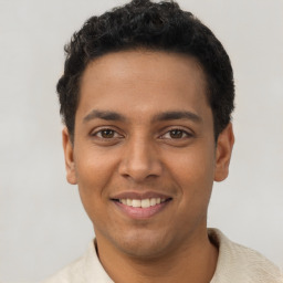 Joyful latino young-adult male with short  black hair and brown eyes