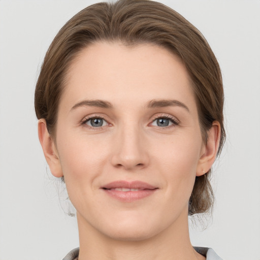 Joyful white young-adult female with medium  brown hair and grey eyes