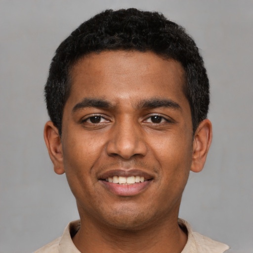 Joyful black young-adult male with short  black hair and brown eyes