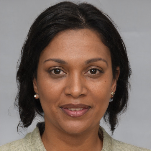 Joyful black adult female with medium  brown hair and brown eyes