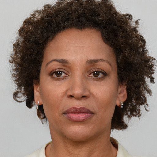 Joyful black adult female with medium  brown hair and brown eyes