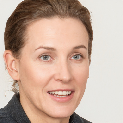 Joyful white adult female with medium  brown hair and grey eyes