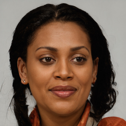 Joyful black adult female with long  brown hair and brown eyes