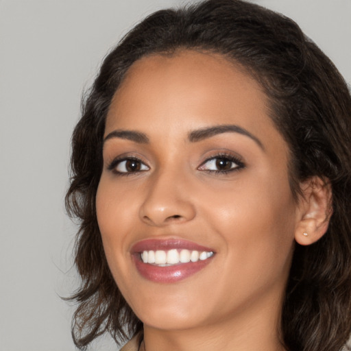 Joyful latino young-adult female with medium  brown hair and brown eyes