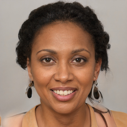 Joyful black adult female with medium  brown hair and brown eyes