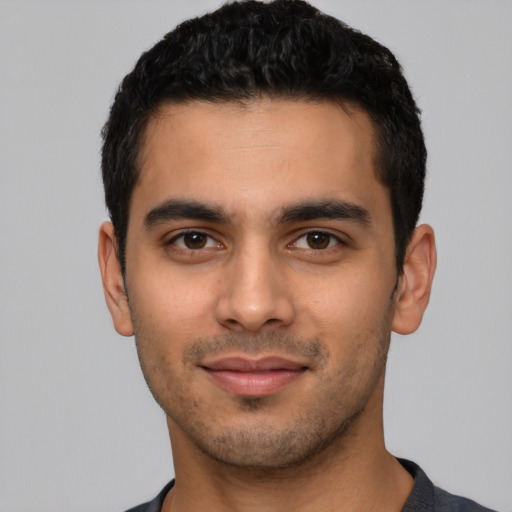 Joyful latino young-adult male with short  black hair and brown eyes