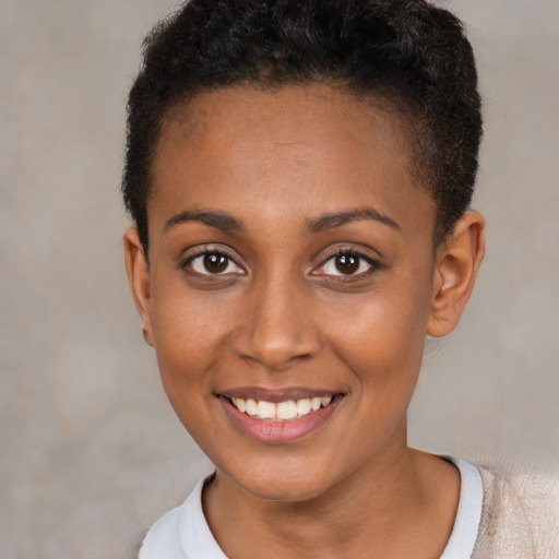 Joyful black young-adult female with short  brown hair and brown eyes