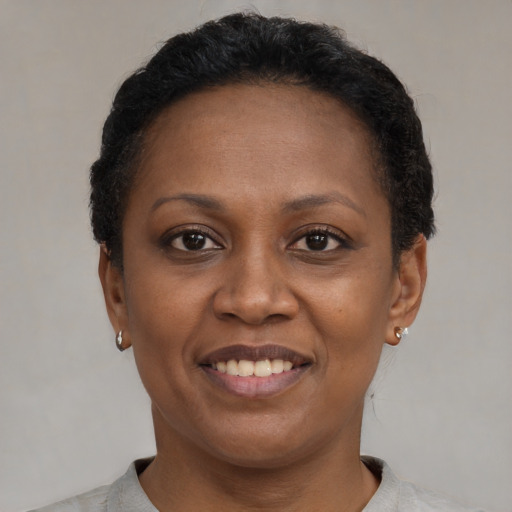 Joyful black adult female with short  brown hair and brown eyes