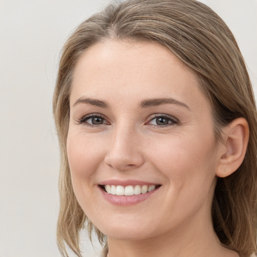 Joyful white young-adult female with medium  brown hair and grey eyes