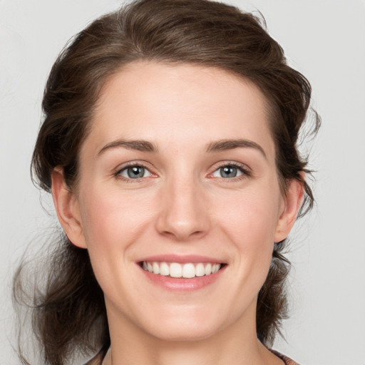 Joyful white young-adult female with medium  brown hair and grey eyes