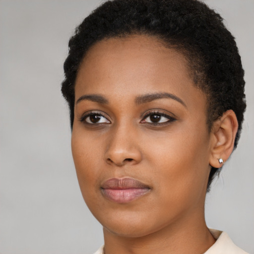 Joyful black young-adult female with short  brown hair and brown eyes