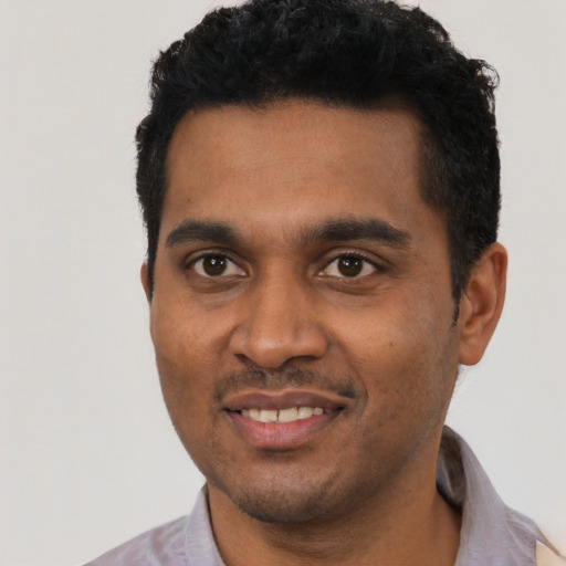 Joyful black young-adult male with short  black hair and brown eyes