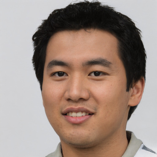 Joyful asian young-adult male with short  black hair and brown eyes