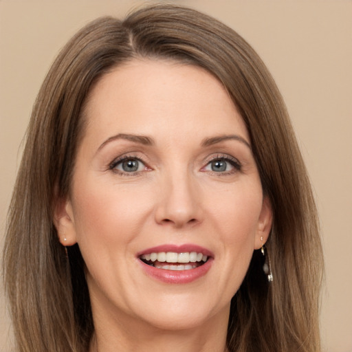 Joyful white adult female with long  brown hair and grey eyes