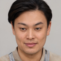 Joyful asian young-adult male with short  brown hair and brown eyes