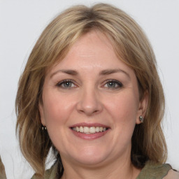 Joyful white adult female with medium  brown hair and grey eyes