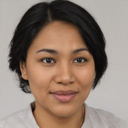 Joyful asian young-adult female with medium  brown hair and brown eyes