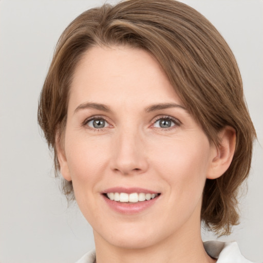 Joyful white young-adult female with medium  brown hair and green eyes