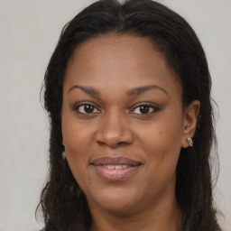 Joyful black adult female with long  brown hair and brown eyes