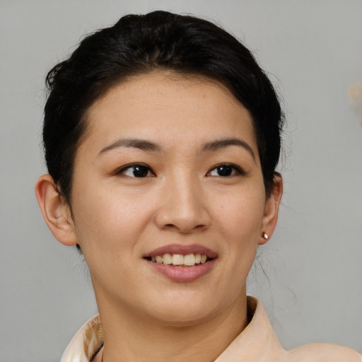 Joyful asian young-adult female with short  brown hair and brown eyes