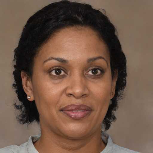 Joyful black adult female with medium  brown hair and brown eyes
