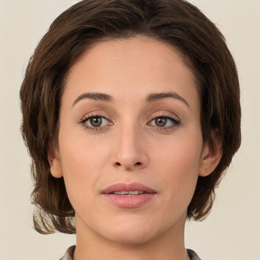 Joyful white young-adult female with medium  brown hair and green eyes