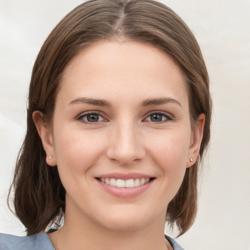 Joyful white young-adult female with medium  brown hair and grey eyes