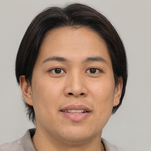 Joyful asian young-adult male with medium  brown hair and brown eyes