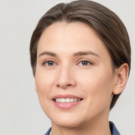 Joyful white young-adult female with medium  brown hair and grey eyes