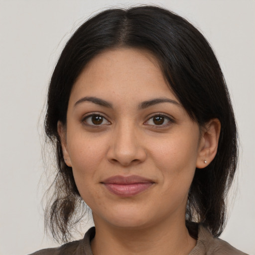Joyful latino young-adult female with medium  brown hair and brown eyes