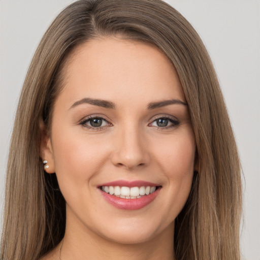 Joyful white young-adult female with long  brown hair and brown eyes