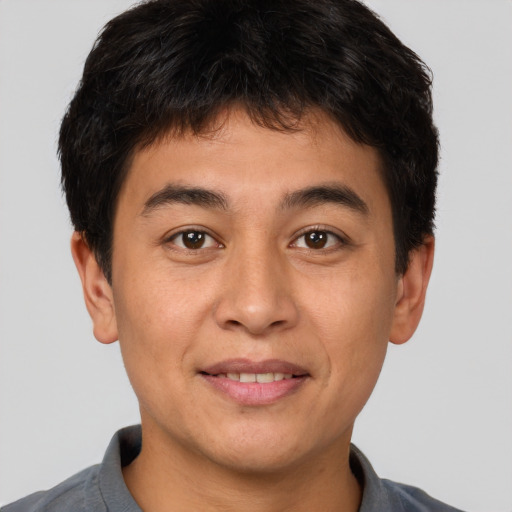Joyful asian young-adult male with short  brown hair and brown eyes