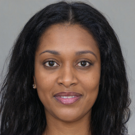 Joyful black young-adult female with long  black hair and brown eyes