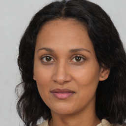 Joyful latino adult female with medium  brown hair and brown eyes