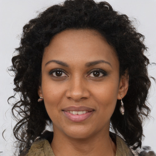 Joyful black young-adult female with long  brown hair and brown eyes