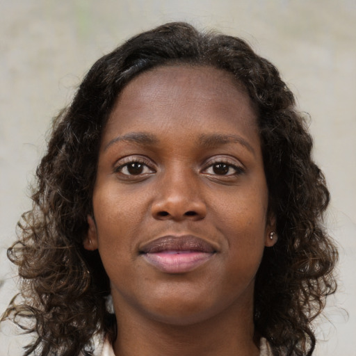 Joyful black young-adult female with medium  brown hair and brown eyes